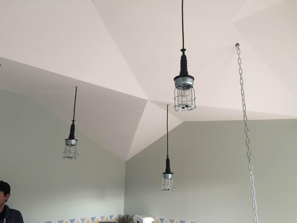 Moulures au plafond pour un effet géométrique avec luminaires style artisanal qui pendent par A&C Nuances Décoration